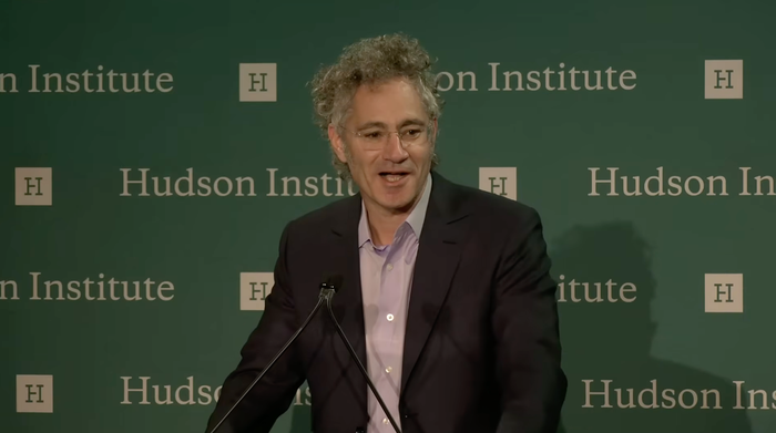 Palantir CEO Alex Karp delivering a speech at a podium.